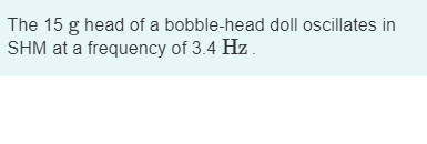 The 15 g head of a bobble-head doll oscillates in SHM at a frequency of 3.4 Hz